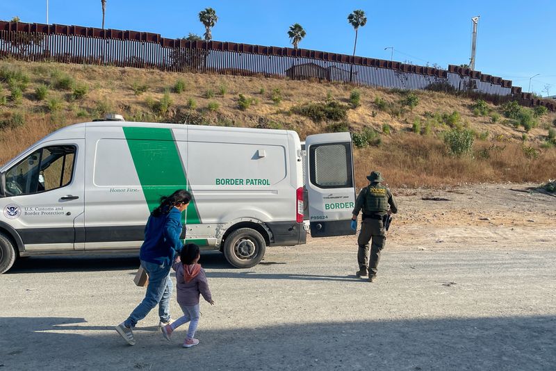 © Reuters. A U.S. Border Patrol agent leads Jessica Leon of Ecuador and her 3-year-old daughter onto a van to be processed in San Diego, California, U.S. June 4, 2024. REUTERS/Daniel Trotta