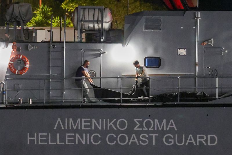 © Reuters. FILE PHOTO: Men transfer body bags carrying migrants who died after their boat capsized in the open sea off Greece, onboard a Hellenic Coast Guard vessel at the port of Kalamata, Greece, June 14, 2023. REUTERS/Stelios Misinas/File Photo