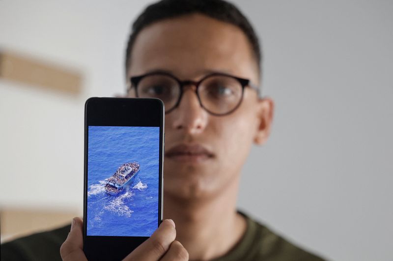 © Reuters. FILE PHOTO: Egyptian Mahmoud Shalabi, 23, one of the 104 survivors of a deadly migrant shipwreck, shows a picture of the fishing trawler Adriana, which sank off southwestern Greece last year, during an interview with Reuters in Athens, Greece, May 22, 2024. REUTERS/Louisa Gouliamaki/File Photo