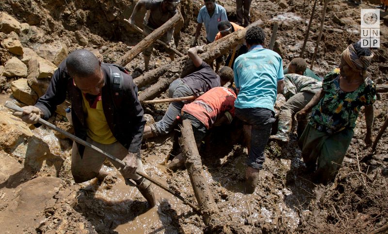 © Reuters. FILE PHOTO: People clear an area at the site of a landslide in Yambali village, Enga Province, Papua New Guinea, May 27, 2024.   UNDP Papua New Guinea/Handout via REUTERS/File Photo