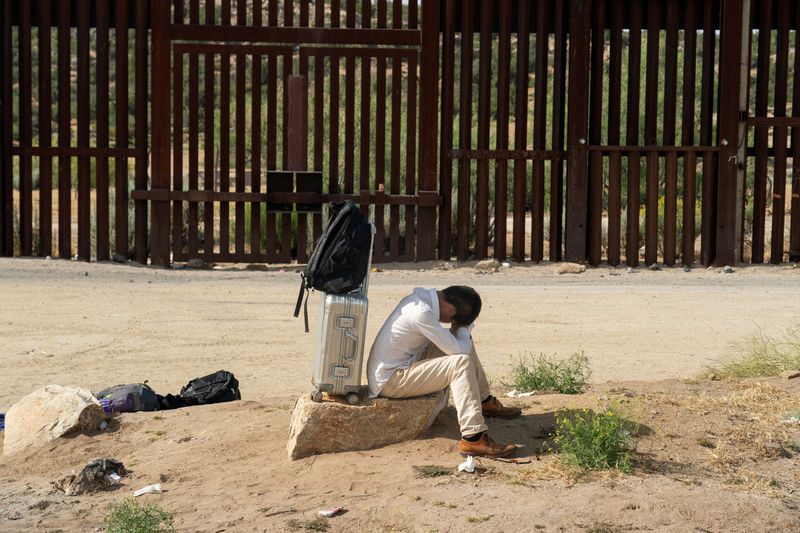 © Reuters. An asylum-seeking migrant from China rests on a rock while waiting to be transported by the U.S. Border Patrol after crossing the border from Mexico into the U.S. in Jacumba Hot Springs, California, U.S. June 4, 2024.  REUTERS/Go Nakamura/ File Photo