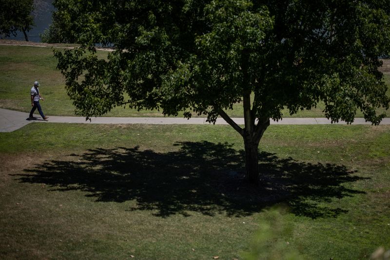 &copy; Reuters. A person walks along a park as temperatures are expected to soar above 100 degrees Fahrenheit (37.8 degrees Celsius) during the summer's first heat, in Sacramento, California, U.S., June 4, 2024. REUTERS/Carlos Barria