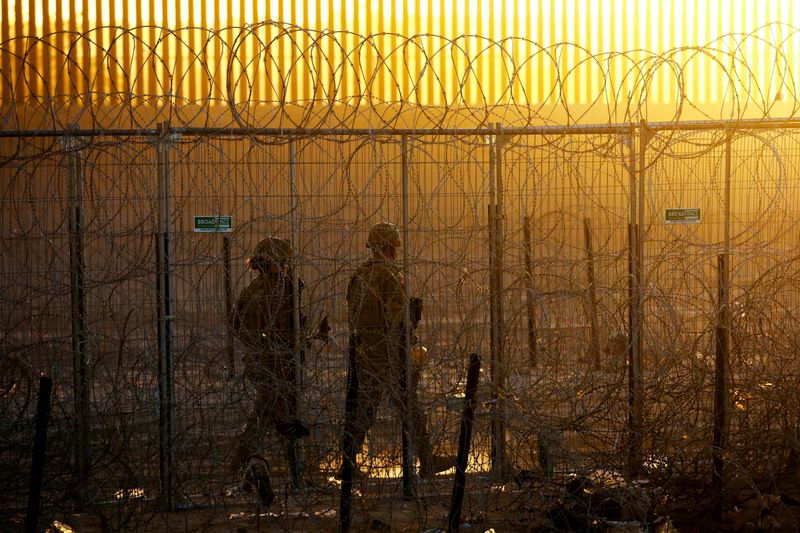 © Reuters. FILE PHOTO: Members of the Texas National Guard stand guard near a razor wire fence to inhibit the crossing of migrants into the United States, seen from Ciudad Juarez, Mexico, June 4, 2024. REUTERS/Jose Luis Gonzalez/File Photo