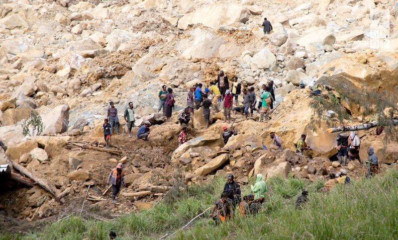 © Reuters. FILE PHOTO: People clear an area at the site of a landslide in Yambali village, Enga Province, Papua New Guinea, May 27, 2024.   UNDP Papua New Guinea/Handout via REUTERS/File Photo