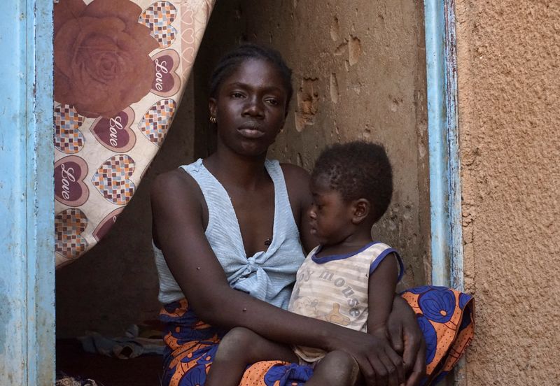 © Reuters. Sybil Esth, a Sierra Leonean migrant, repatriated from Algeria six months ago, looks on while holding her child in Agadez, Niger, April 23, 2024. REUTERS/Stringer