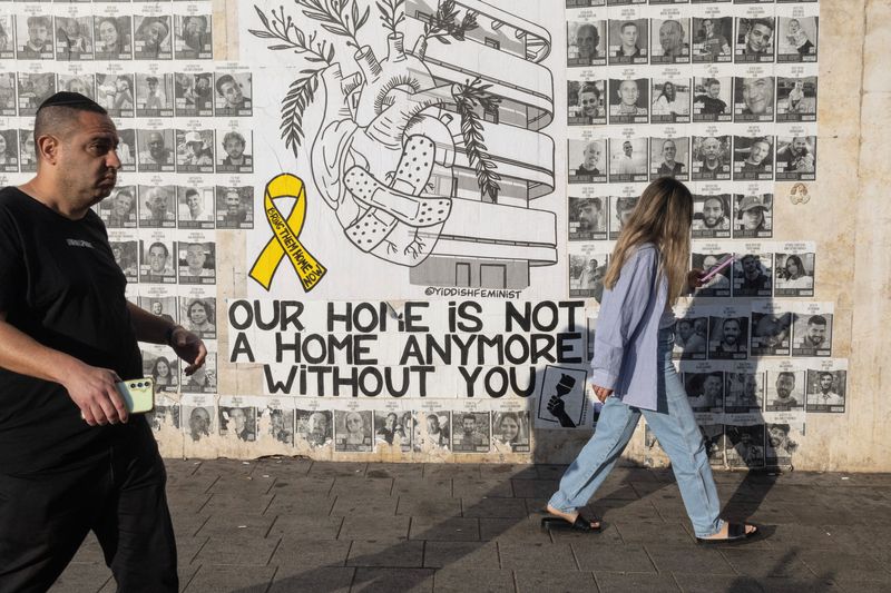 © Reuters. People pass by posters of hostages kidnapped during the deadly October 7 attack by Hamas, in Tel Aviv, Israel, June 7, 2024. REUTERS/Marko Djurica/File Photo