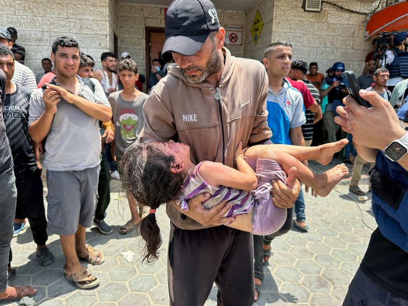 © Reuters. SENSITIVE MATERIAL. THIS IMAGE MAY OFFEND OR DISTURB: A man carries a casualty in the aftermath of an Israeli strike, amid the Israel-Hamas conflict, at Al-Aqsa Martyrs Hospital in Deir Al-Balah, in the central Gaza Strip, June 8, 2024. REUTERS/Doaa Rouqa