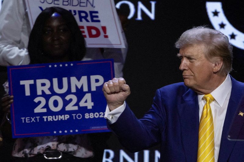 © Reuters. FILE PHOTO: Republican presidential candidate and former U.S. President Donald Trump gestures as a supporter looks on during a Turning Point USA event at the Dream City Church in Phoenix, Arizona, U.S., June 6, 2024. REUTERS/Carlos Barria/File Photo