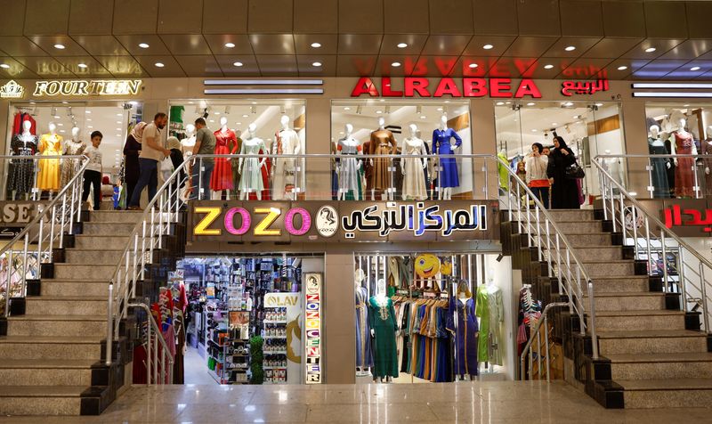 © Reuters. People walk past stores as rebuilding work continues in Mosul, Iraq June 9, 2024, 10 years after Islamic State militants seized control of the city and ruled for three years before being ousted by Iraqi forces and their allies. REUTERS/Khalid Al-Mousily