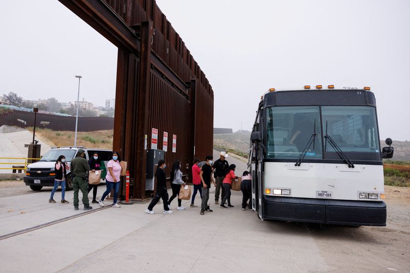 © Reuters. FILE PHOTO: U.S. Border Patrol agents use a bus to transport migrants who overnight gathered between the primary and secondary border walls that separate Mexico and the United States, after tough new restrictions imposed by U.S. President Biden in San Diego, California,U.S., June 6, 2024.   REUTERS/Mike Blake/File Photo