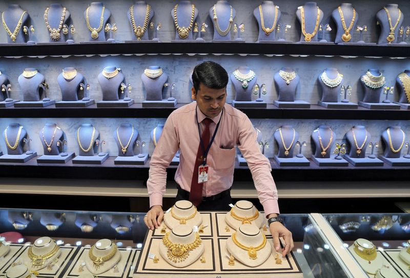 &copy; Reuters. FILE PHOTO: A salesman displays gold necklaces and earrings inside a jewellery showroom on the occasion of Akshaya Tritiya, a major gold buying festival, in Mumbai, India, May 7, 2019. REUTERS/Francis Mascarenhas/File Photo