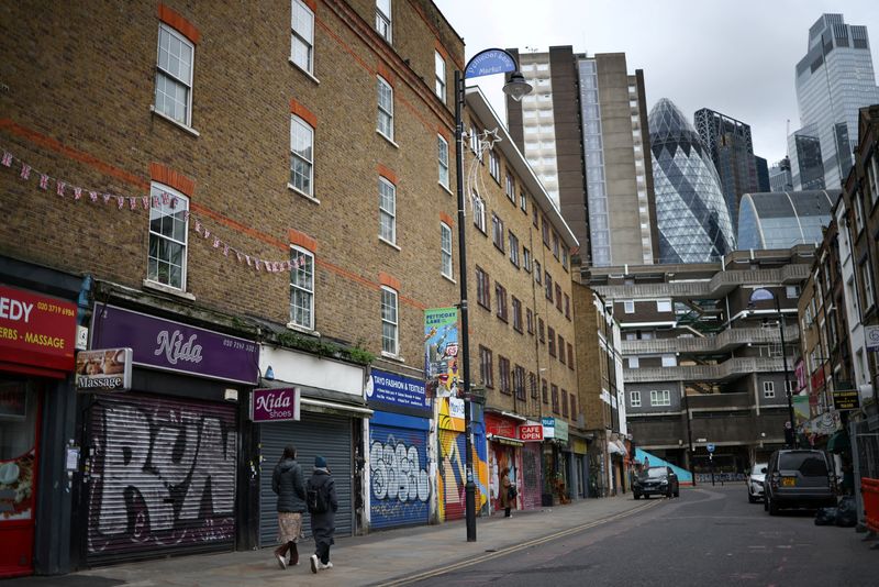 &copy; Reuters. FILE PHOTO: People walk past shops, with the City of London financial district in the background, in London, Britain, February 4, 2023. REUTERS/Henry Nicholls/File Photo