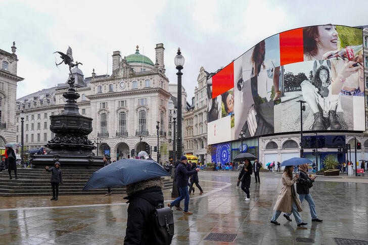 © Reuters. Pedestrians carrying umbrellas walk at Piccadilly Circus, in London, Britain, April 28, 2024. REUTERS/Maja Smiejkowska/files