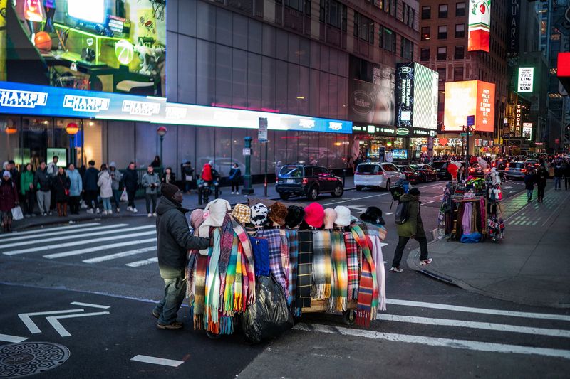 &copy; Reuters. FILE PHOTO: A man pushes his cart with merchandise to sell, in Times Square, New York, U.S., December 25, 2023. REUTERS/Eduardo Munoz