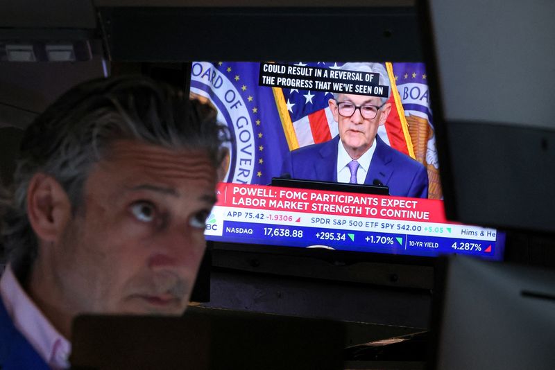© Reuters. A trader works, as a screen broadcasts a news conference by U.S. Federal Reserve Chair Jerome Powell following the Fed rate announcement, on the floor of the New York Stock Exchange (NYSE) in New York City, U.S., June 12, 2024.  REUTERS/Brendan McDermid
