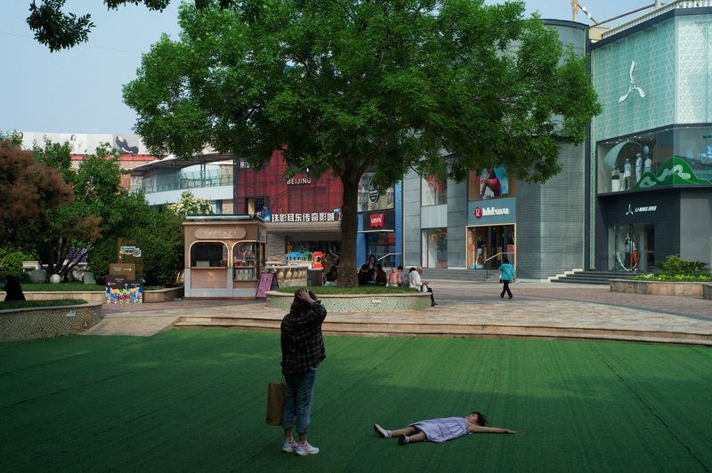 &copy; Reuters. FILE PHOTO: A child rests on the ground on a summer day at a shopping complex in Beijing, China May 22, 2024. REUTERS/Tingshu Wang/File Photo