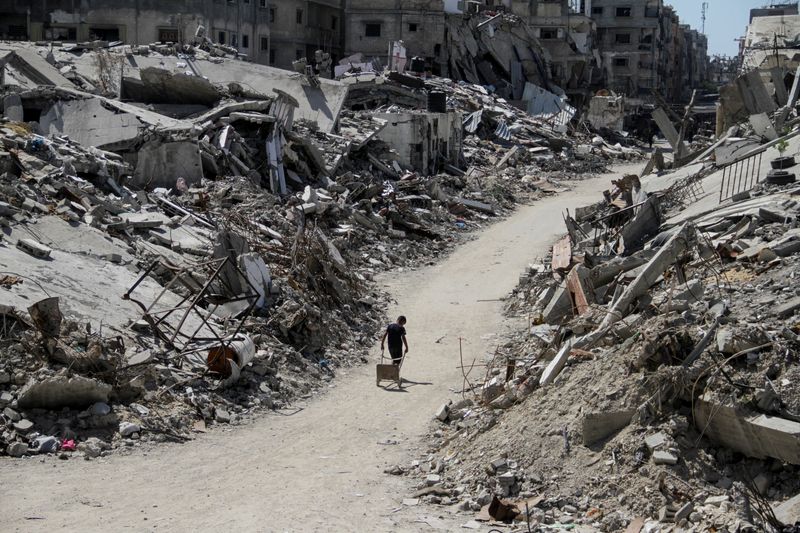 &copy; Reuters. Um palestino caminha entre escombros de edifícios, destruídos durante a ofensiva militar de Israel em Beit Lahia, no norte da Faixa de Gazan12/06/2024nREUTERS/Mahmoud Issa