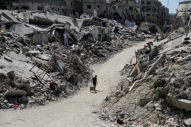 © Reuters. A Palestinian walks among the rubble of damaged buildings, which were destroyed during Israel's military offensive, amid the ongoing conflict between Israel and Hamas, in Beit Lahia in the northern Gaza Strip, June 12, 2024. REUTERS/Mahmoud Issa