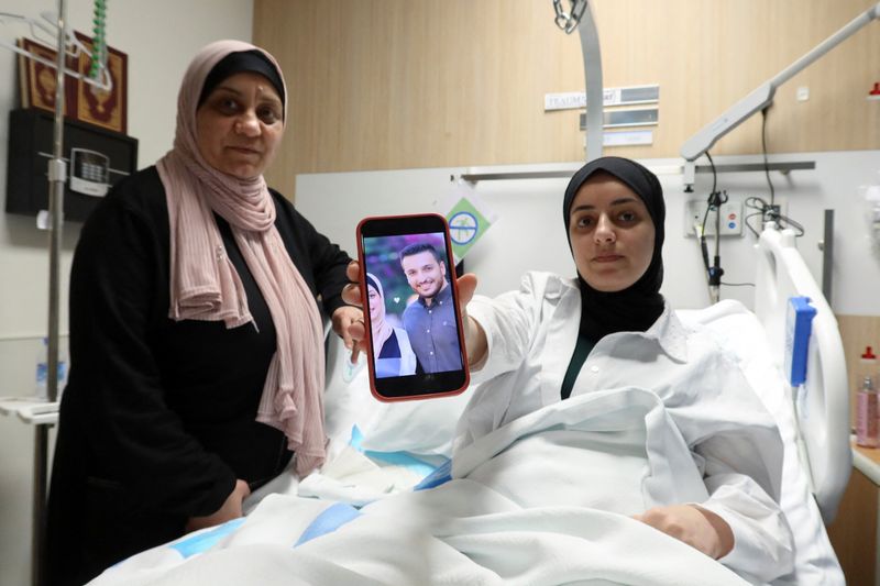 © Reuters. Shahed Al-Kotati, a wounded from Gaza, shows the picture of her killed husband as she sits in bed at a hospital in Doha, Qatar, June 6, 2024. REUTERS/Imad Creidi