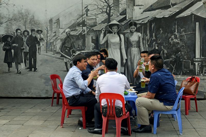 &copy; Reuters. FILE PHOTO: Men drink beer on the street in Hanoi, Vietnam April 5, 2021. REUTERS/Thanh Hue/File Photo