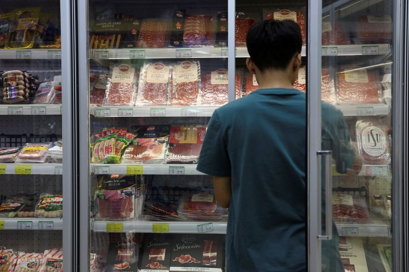 &copy; Reuters. Un membro del personale ripone in un congelatore carne di maiale e altri prodotti a base di carne, in un supermercato di Pechino, in Cina, 13 giugno 2024. REUTERS/Florence Lo