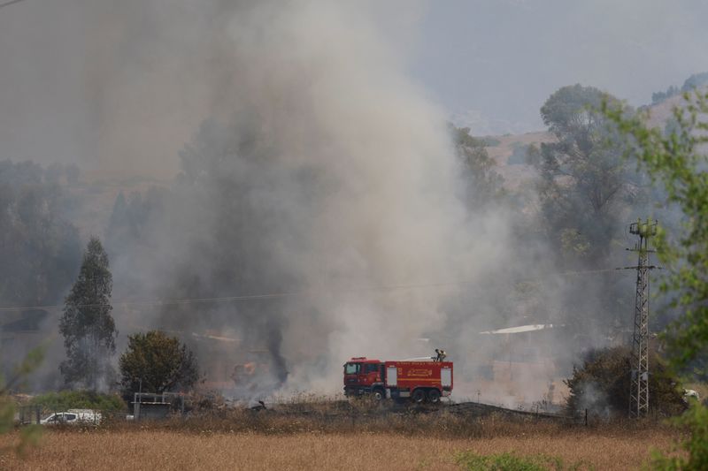 © Reuters. Firefighters respond to a fire near a rocket attack from Lebanon, amid ongoing cross-border hostilities between Hezbollah and Israeli forces, near Kiryat Shmona, northern Israel, June 14, 2024. REUTERS/Ammar Awad