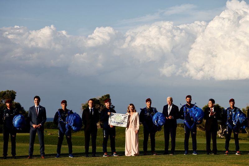 © Reuters. Italy's Prime Minister Giorgia Meloni holds a G7 Italia banner next to U.S. President Joe Biden, Canada's Prime Minister Justin Trudeau, France's President Emmanuel Macron and Japan's Prime Minister Fumio Kishida on the first day of the G7 summit, in Savelletri, Italy, June 13, 2024. REUTERS/Yara Nardi