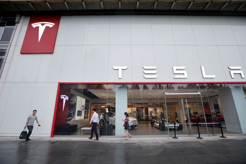&copy; Reuters. FILE PHOTO: People walk past a showroom outside Tesla China headquarters at China Central Mall in Beijing, China July 11, 2018. REUTERS/Jason Lee/File Photo