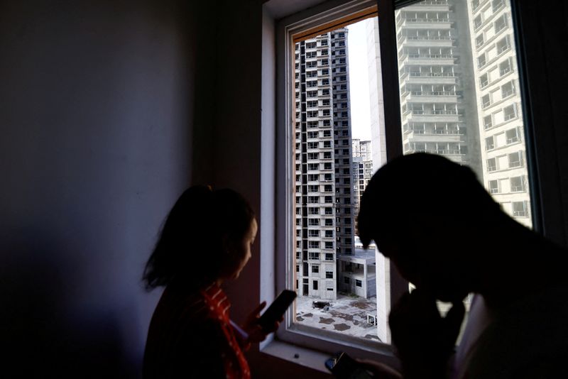 © Reuters. Home buyers stand near a window at an unfinished residential building of the Gaotie Wellness City complex in Tongchuan, Shaanxi province, China September 12, 2023. REUTERS/Tingshu Wang/file photo