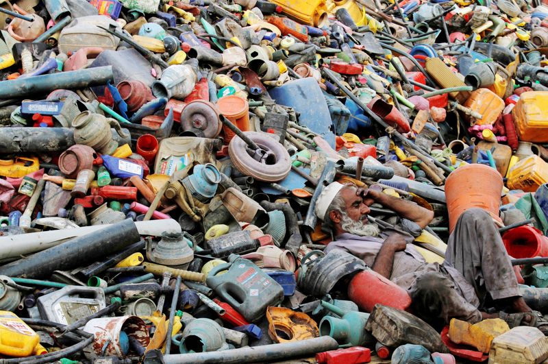 © Reuters. FILE PHOTO: A labourer rests over a pile of recyclables at a yard in Peshawar, Pakistan, August 17, 2017. REUTERS/Fayaz Aziz/File Photo