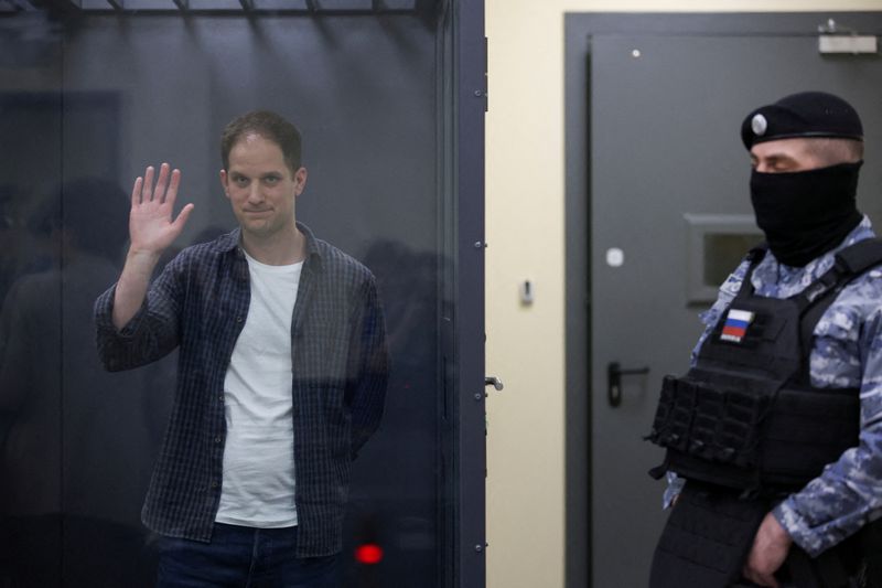 &copy; Reuters. FILE PHOTO: Wall Street Journal reporter Evan Gershkovich, who is in custody on espionage charges, waves behind a glass wall of an enclosure for defendants as he attends a court hearing in Moscow, Russia, April 23, 2024. REUTERS/Tatyana Makeyeva/File Phot
