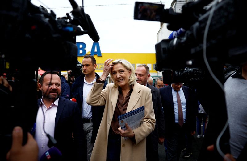 © Reuters. FILE PHOTO: Marine Le Pen, French far-right leader and French far-right National Rally (Rassemblement National - RN) party candidate in the upcoming parliamentary elections, distributes leaflets as she campaigns with Henin-Beaumont mayor Steeve Briois and local RN politician Bruno Bilde at a market in Henin-Beaumont, northern France, June 14, 2024. REUTERS/Sarah Meyssonnier   