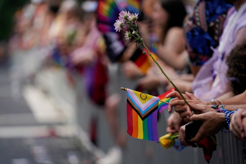 &copy; Reuters. FILE PHOTO: People hold flowers and flags during the annual LGBTQ+ Capital Pride parade in Washington, U.S., June 8, 2024. REUTERS/Nathan Howard/File Photo