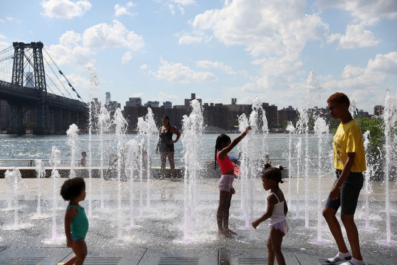 &copy; Reuters. FILE PHOTO: People cool off in a water feature in Domino Park as a heat wave hit the region in Brooklyn, New York City, U.S., August 8, 2022. REUTERS/Andrew Kelly/File Photo