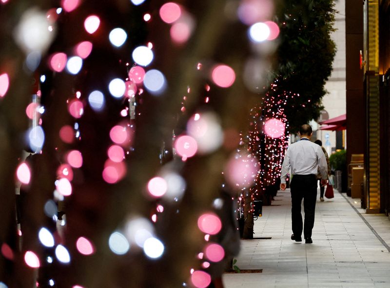 &copy; Reuters. FILE PHOTO: An office worker walks past illuminated trees at a business district in Tokyo, Japan January 23, 2024. REUTERS/Kim Kyung-Hoon/File Photo