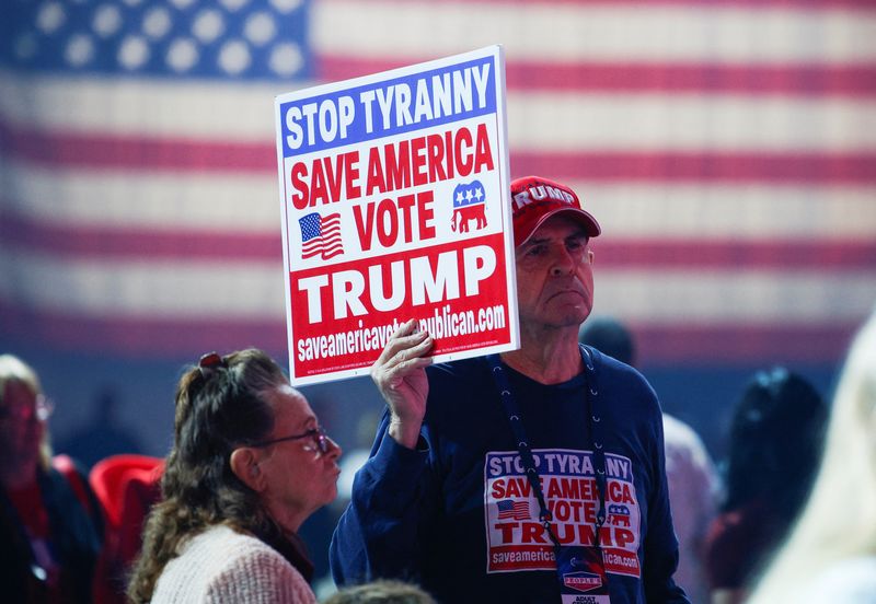 &copy; Reuters. A supporter of Republican presidential candidate Donald Trump holds a sign during an event held by the national conservative political movement, 'Turning Point' in Detroit, Michigan, U.S., June,  16, 2024. REUTERS/Rebecca cook/File Photo