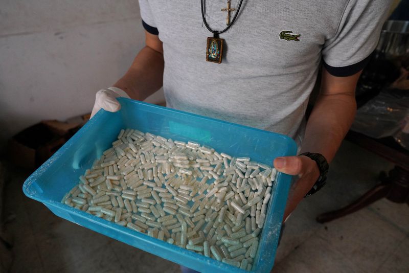 &copy; Reuters. FILE PHOTO: A member of the Sinaloa Cartel shows capsules with methamphetamine in a safe house in Culiacan, Mexico, April 4, 2022. REUTERS/Alexandre Meneghini/File Photo