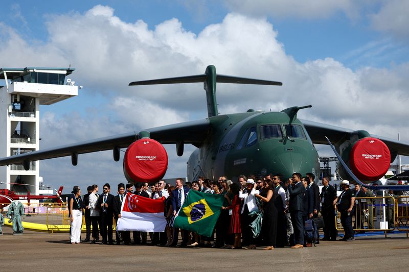 &copy; Reuters. Delegação brasileira posa para fotos diante de uma aeronave Embraer C-390 Millennium durante feira aérea em Cingapuran20/02/2024nREUTERS/Edgar Su