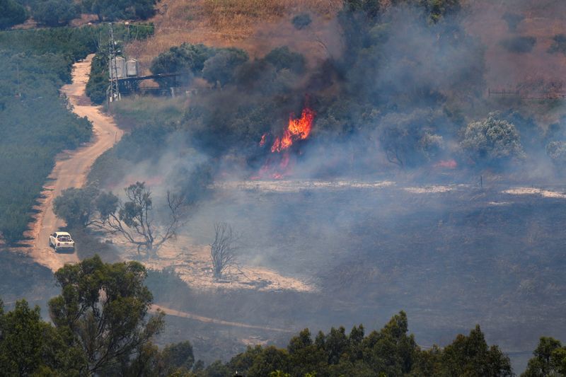 © Reuters. A fire blazes on the Israeli side of the Israel-Lebanon border following attacks from Lebanon, amid cross-border hostilities between Hezbollah and Israeli forces, in northern Israel June 18, 2024. REUTERS/Ayal Margolin