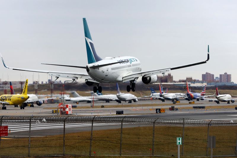 © Reuters. A Westjet Airlines jet lands in front of planes backed up waiting to depart on the runway after flights earlier were grounded during an FAA system outage at Laguardia Airport in New York City, New York, U.S., January 11, 2023. REUTERS/Mike Segar/ File Photo