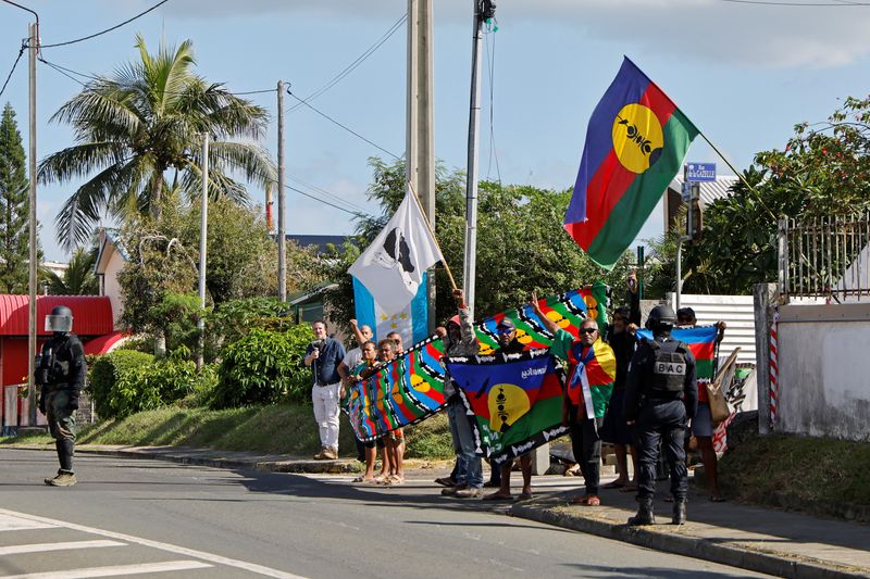 &copy; Reuters. FILE PHOTO: People demonstrate as French President Emmanuel Macron's motorcade drives past in Noumea, France's Pacific territory of New Caledonia on May 23, 2024.     LUDOVIC MARIN/Pool via REUTERS/File Photo