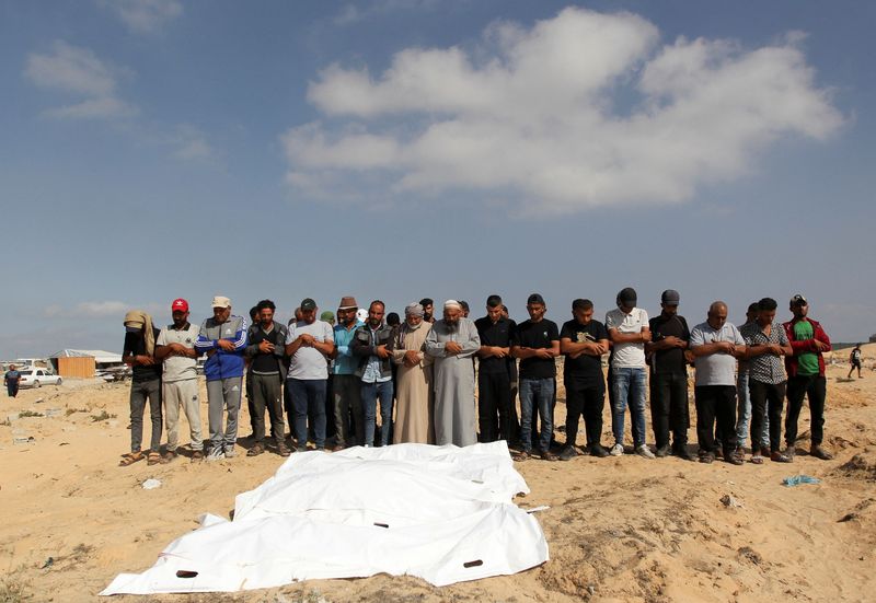 &copy; Reuters. I fedeli pregano accanto ai corpi dei palestinesi uccisi dai colpi israeliani a causa di un'operazione militare israeliana a Rafah, nell'ambito del conflitto in corso tra Israele e Hamas, a Khan Younis, nel sud della Striscia di Gaza, il 19 giugno 2024. R