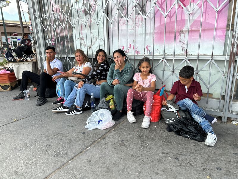 © Reuters. Venezuelan migrant Yenny Cisneros sits with her daughter, and other migrants after being admitted into the United States using the CBP One app, outside a shopfront in El Paso, Texas, U.S., June 14, 2024. REUTERS/Andrew Hay