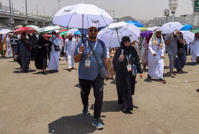 © Reuters. Muslim pilgrims holding umbrellas walk on the third day of the Satan stoning ritual, amid extremely hot weather, during the annual haj pilgrimage, in Mina, Saudi Arabia, June 18, 2024. REUTERS/Saleh Salem