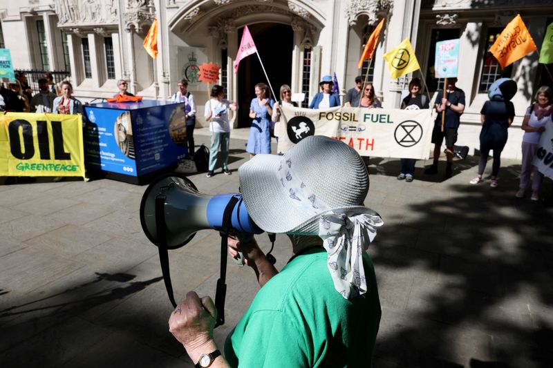 © Reuters. A person uses a megaphone as climate activists await a ruling on whether planning permission granted for oil wells in southern England was lawful, outside the Supreme Court in London, Britain, June 20, 2024. REUTERS/Kevin Coombs