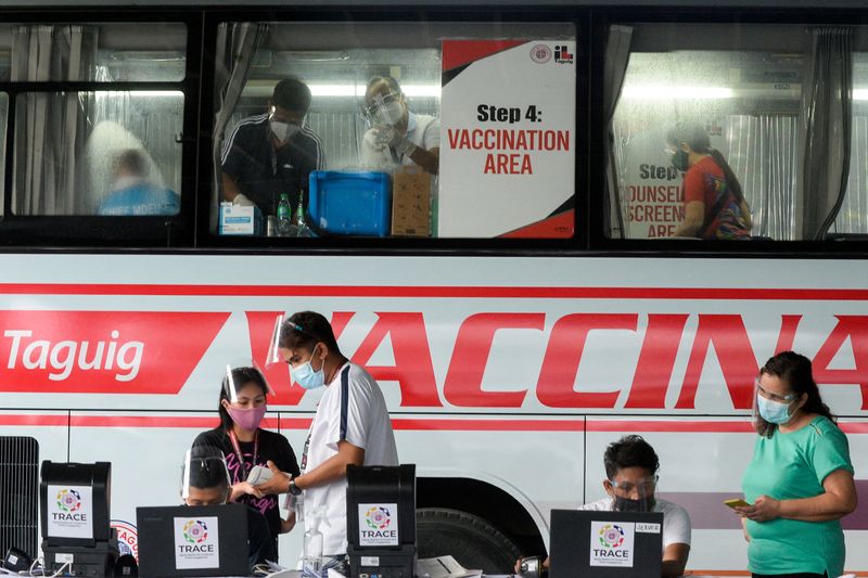&copy; Reuters. FILE PHOTO: Health workers encode information and prepare vaccines against the coronavirus (COVID-19) at a mobile vaccination site in Taguig, Metro Manila, Philippines, May 21, 2021. REUTERS/Lisa Marie David/File Photo