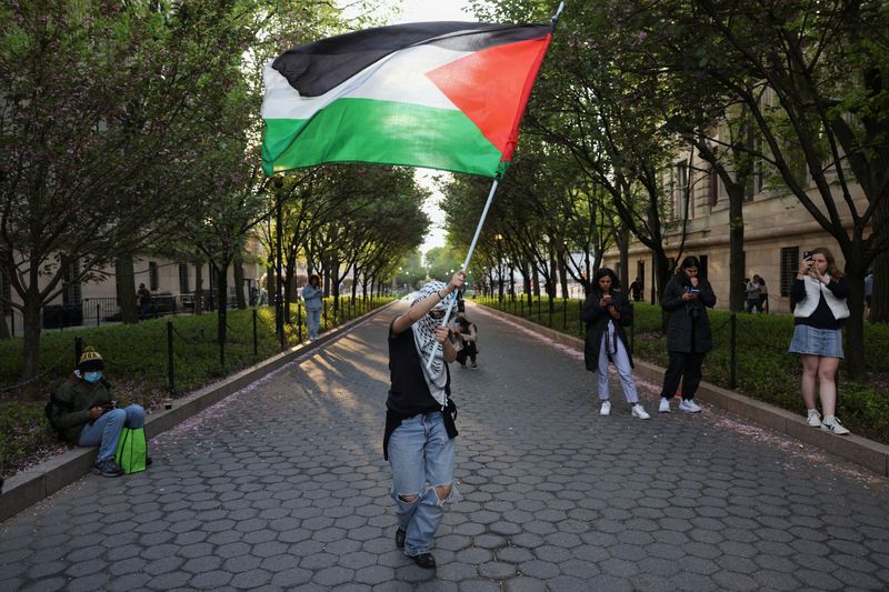 &copy; Reuters. File photo: A person holds a Palestinian flag as people continue protesting inside and outside Columbia University, where students escalated protests in support of Palestinians, by barricading themselves inside Hamilton Hall, despite orders from universit