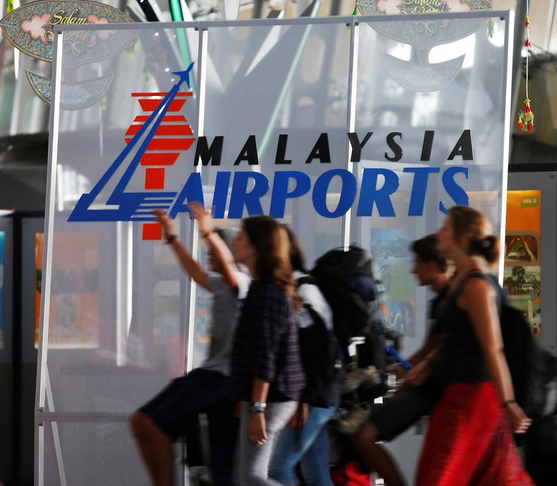 &copy; Reuters. FILE PHOTO: Travellers push their trolley past a logo of Malaysia Airports at the departure hall of Kuala Lumpur International Airport in Sepang, outside Kuala Lumpur August 26, 2013. REUTERS/Bazuki Muhammad/File Photo