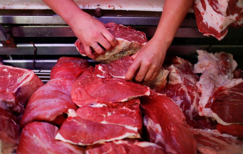 © Reuters. FILE PHOTO: Butcher Pablo Alberto Monzon selects a piece of meat at his shop, in General Pacheco, on the outskirts of Buenos Aires, Argentina May 19, 2021. Picture taken May 19, 2021.  REUTERS/Agustin Marcarian/File Photo