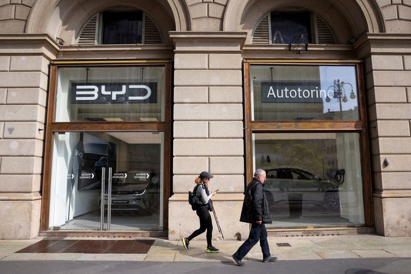 © Reuters. FILE PHOTO: People walk in front of BYD Auto company and Autotorino store in Milan, Italy, March 20, 2024. REUTERS/Claudia Greco/File Photo